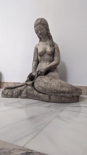a statue of a woman sitting on a pillow at Casa de la Sirena in Baena