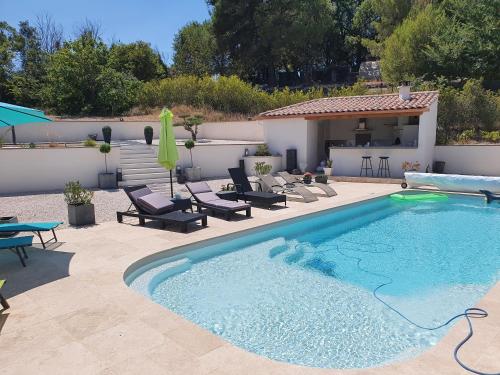 a swimming pool with chairs and a house at BELLE VILLA 8 à 10 personnes parc du verdon in La Verdière