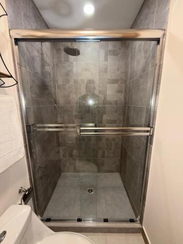 a glass shower in a bathroom with a toilet at New and Luxurious Apt in Cipreses de San Ignacio in Tegucigalpa