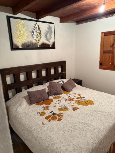 a bedroom with a bed with a flower pattern on it at Hotel del Pozo in San Sebastián del Oeste