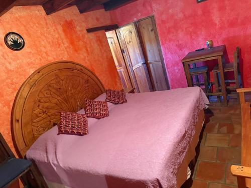 a bedroom with a bed with a wooden headboard at Hotel del Pozo in San Sebastián del Oeste