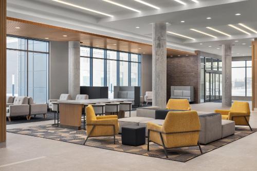 an office lobby with chairs and tables and windows at Holiday Inn Express Montreal Airport - St-Laurent by IHG in Montréal