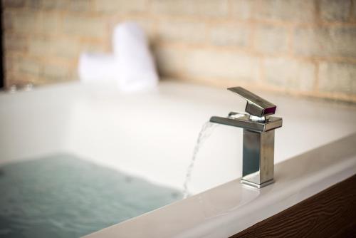 a bathroom sink with a faucet with water at Villa de Vino in Ioannina