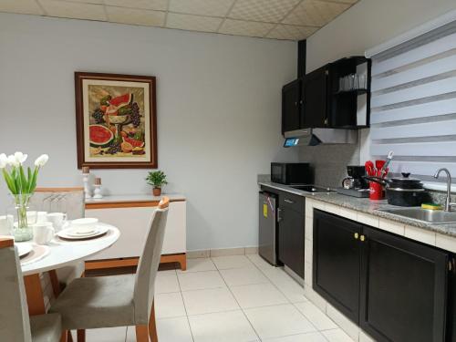 a kitchen with a table and a counter top at Apartamentos Marconela in San Mateo