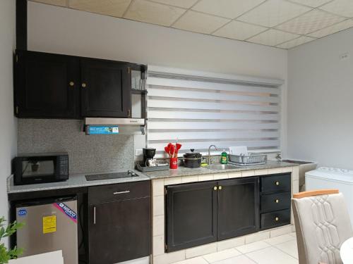 a kitchen with black cabinets and a counter top at Apartamentos Marconela in San Mateo