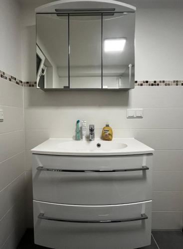 a bathroom with a white sink and a mirror at Frisch Renovierte Souterrain Wohnung in Rodenbach