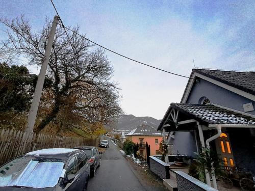 a street with cars parked next to a house at Mountains Galerie Apartment Hana in Chvalov