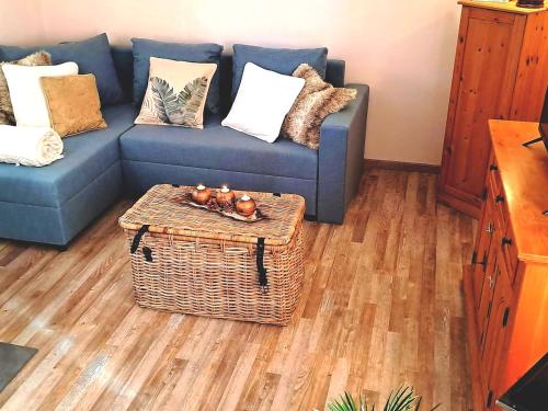 a living room with a blue couch and a table at Mountains Galerie Apartment Hana in Chvalov