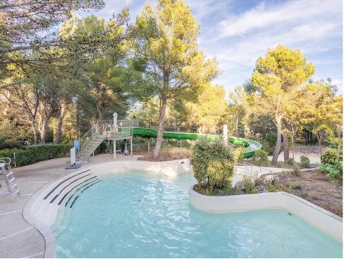 - une piscine avec toboggan dans un parc dans l'établissement Appartement Village P&V domaine du golf Pont Royal Provence avec PARC AQUATIQUE, à Mallemort