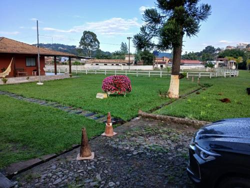a yard with a fence and a tree and a car at Pousada da Elizângela de Amarantina in Ouro Preto