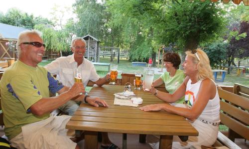 um grupo de pessoas sentadas à mesa com bebidas em Georgshof em Podersdorf am See