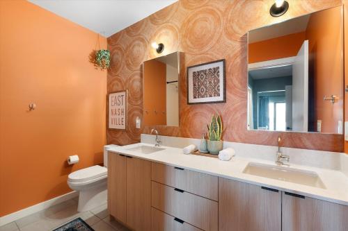 Un baño con lavabo, inodoro y espejo. en Hyve, en Nashville