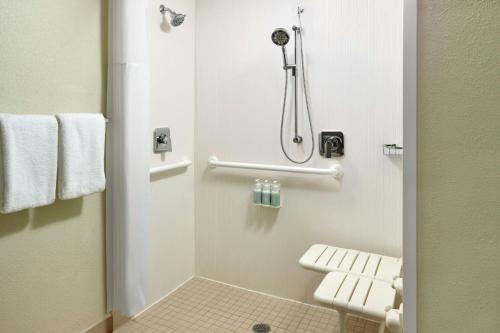 a small bathroom with a shower and a toilet at Courtyard By Marriott Hartford Windsor Airport in Windsor