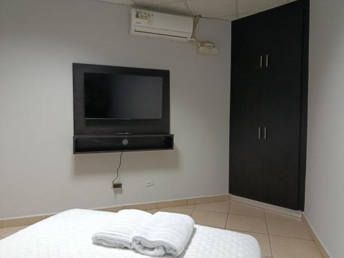 a bedroom with a tv and two towels on a bed at Apartamentos Marconela in San Mateo
