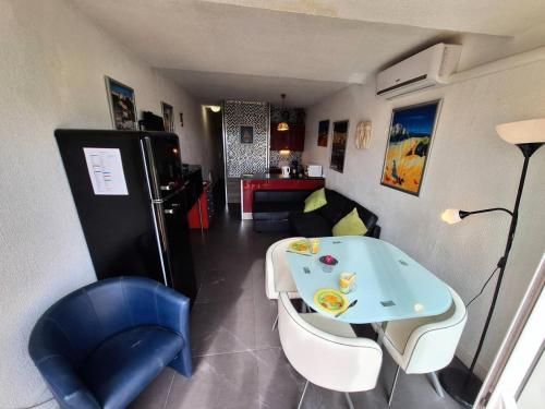 une pièce avec une table, des chaises et un canapé dans l'établissement Résidence Port Nature Colline 8 - Résidence Port Nature Colline 8 – Rez-de-jardin - Sud MAE-3371, au Cap d'Agde