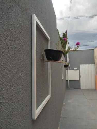 a window with a pot on the side of a building at Flats Ivy no centro de Palmas in Palmas