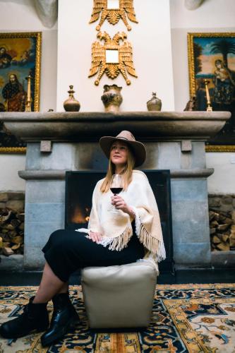 a woman sitting in a chair with a glass of wine at Casa Andina Premium Cusco in Cusco