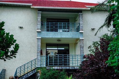 a house with a balcony in front of it at Good News Hotel in Kigali