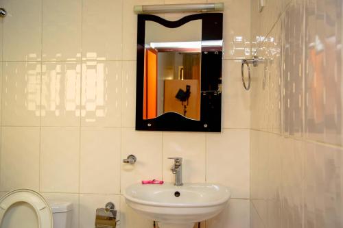 a bathroom with a sink and a mirror on the wall at Good News Hotel in Kigali