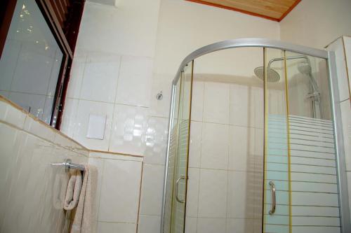 a shower with a glass door in a bathroom at Good News Hotel in Kigali