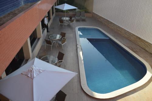 an overhead view of a swimming pool with tables and umbrellas at Annamar Hotel in João Pessoa