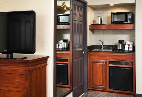 a bathroom with a tv and a kitchen with a sink at Sheraton Fairplex Suites & Conference Center in Pomona