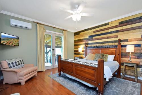 a bedroom with a bed and a wooden wall at Boone Mountain Getaway- Hot Tub Firepit in Boone