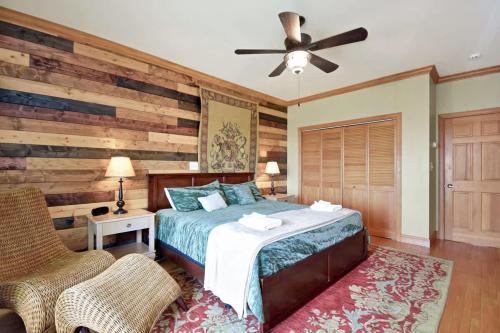 a bedroom with a bed and a wooden wall at Boone Mountain Getaway- Hot Tub Firepit in Boone