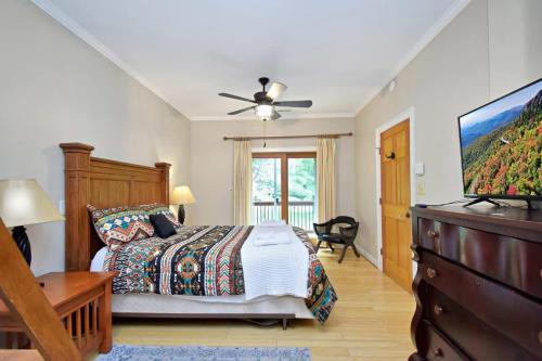 a bedroom with a bed and a flat screen tv at Boone Mountain Getaway- Hot Tub Firepit in Boone