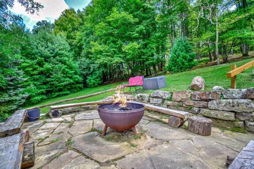a fire pit in a yard with a stone wall at Boone Mountain Getaway- Hot Tub Firepit in Boone