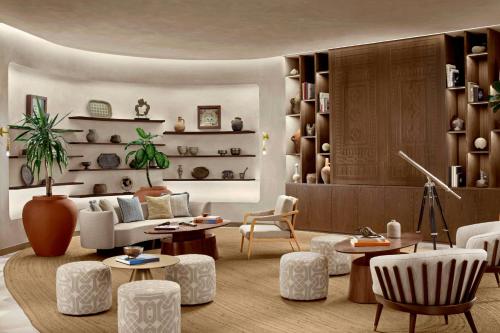 a living room with a couch and tables and chairs at Nujuma, a Ritz-Carlton Reserve in Ḩanak