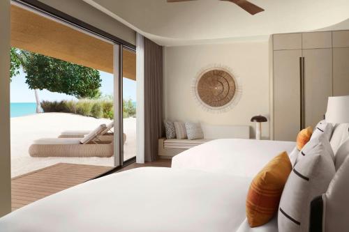 a bedroom with a bed and a view of the ocean at Nujuma, a Ritz-Carlton Reserve in Ḩanak