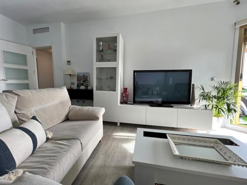 a living room with a couch and a tv at Fuengirola, Doña Sofia amazing sea view in Fuengirola