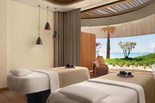a room with two beds and a view of the ocean at Nujuma, a Ritz-Carlton Reserve in Ḩanak