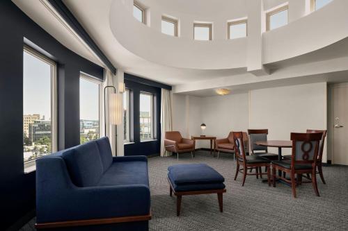a living room with a blue couch and chairs and a table at Courtyard by Marriott Halifax Downtown in Halifax
