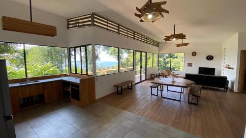 a living room with a table and some windows at Tropical Sea View Villa in Puerto Viejo