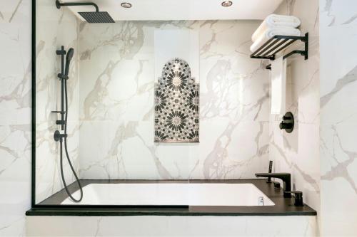 a bathroom with a bath tub and a sink at Le Meridien N'fis in Marrakech