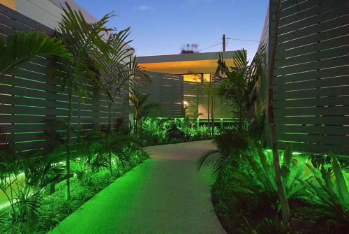 a walkway with green lighting in front of a building at Cavvanbah - April Sun Villa - Construction Zone Warning in Byron Bay