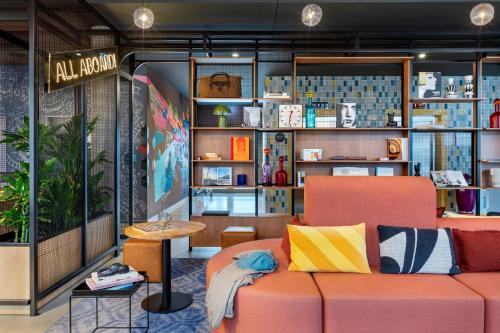 a living room with a couch and a table at Moxy Berlin Ostbahnhof in Berlin