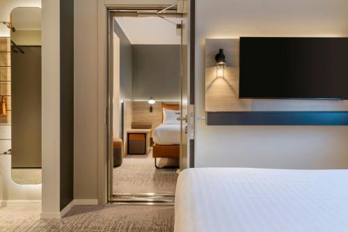 a hotel room with a bed and a television at Moxy Berlin Ostbahnhof in Berlin