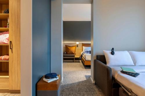 a hotel room with a bed and a couch at Moxy Berlin Ostbahnhof in Berlin