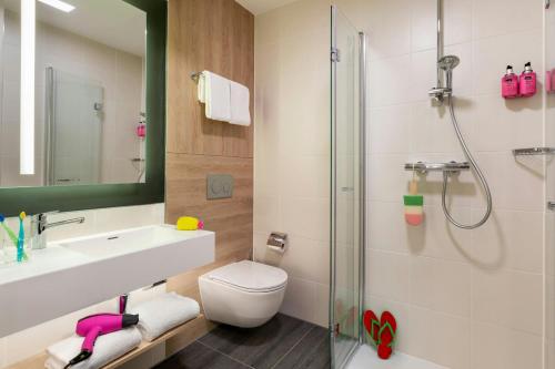 a bathroom with a toilet and a sink and a shower at Moxy Berlin Ostbahnhof in Berlin