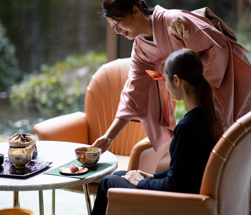 a woman is serving a womanasteryasteryasteryasteryasteryasteryasteryasteryasteryastery at RIHGA Royal Hotel Osaka, Vignette Collection by IHG in Osaka