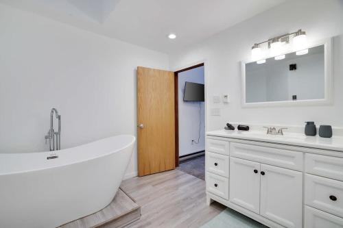 a white bathroom with a tub and two sinks at Relax in Blakeslee - Spacious 5BR Home with BBQ in Blakeslee