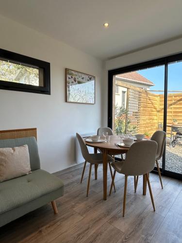 a dining room with a table and chairs at La Cabane in Quiberville
