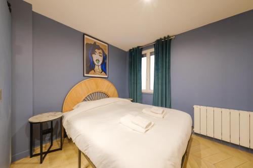 Cette petite chambre comprend un lit avec des draps blancs. dans l'établissement Beautiful Apartment 4p - Gare de l'Est, à Paris