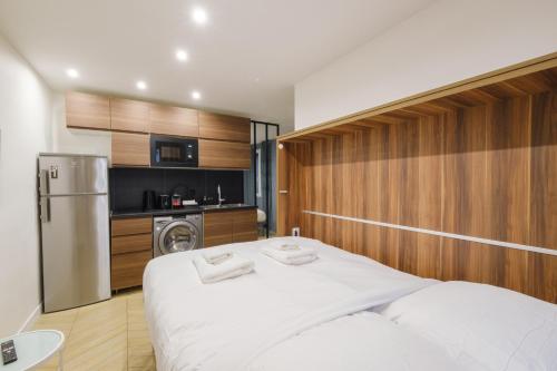 - une chambre avec un lit blanc et un réfrigérateur dans l'établissement Beautiful Apartment 4p - Gare de l'Est, à Paris