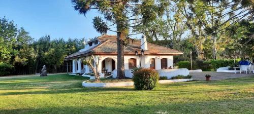 a small house in a yard with a tree at Casa de campo para hospeda y eventos in Villa Estanislao S. Zeballos