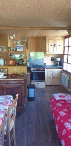 une petite cuisine avec cuisinière et table avec sidx sidx sidx dans l'établissement Les Vardasses - Chalet typique avec jardin et vue sur les montagnes, aux Houches