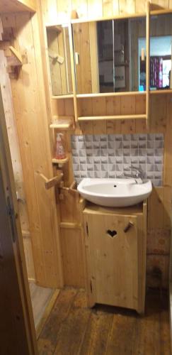 La salle de bains est pourvue d'un lavabo et de placards en bois. dans l'établissement Les Vardasses - Chalet typique avec jardin et vue sur les montagnes, aux Houches